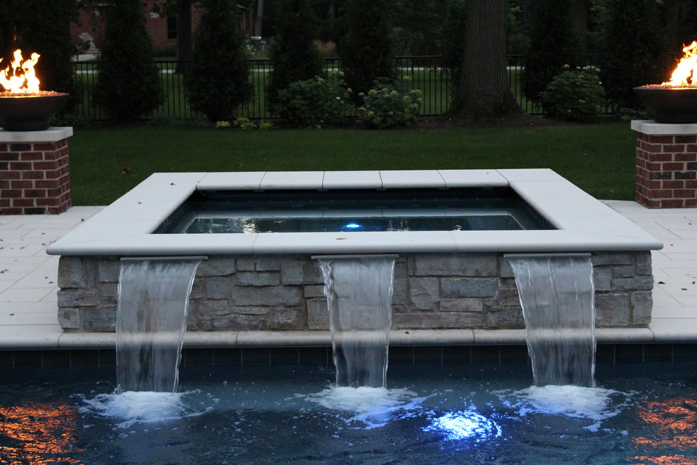 Diseño de piscina con fuente tradicional grande rectangular en patio trasero