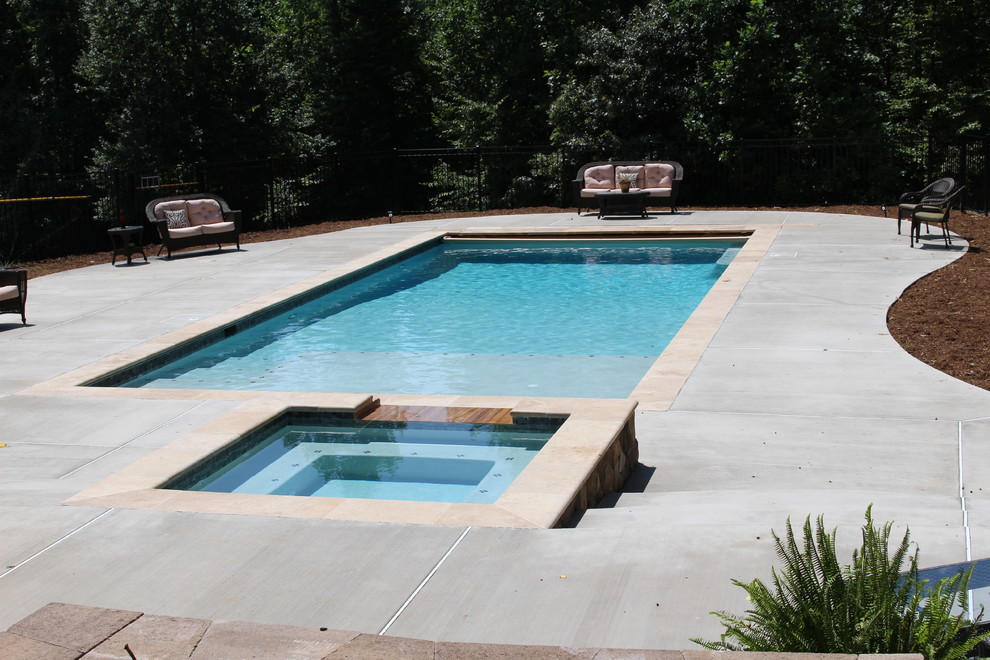 Ejemplo de piscina con fuente natural clásica de tamaño medio rectangular en patio trasero