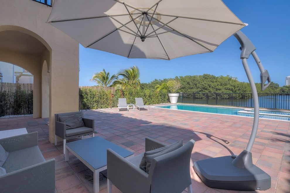Pool - large modern backyard rectangular lap pool idea in Miami