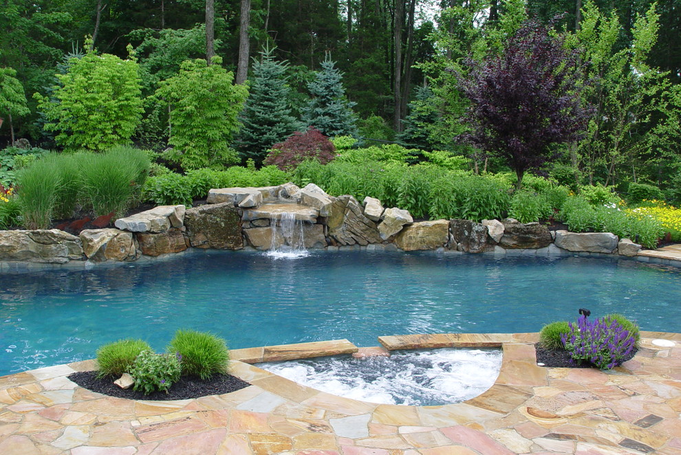 На фото: бассейн среднего размера, произвольной формы на заднем дворе в морском стиле с фонтаном и покрытием из каменной брусчатки