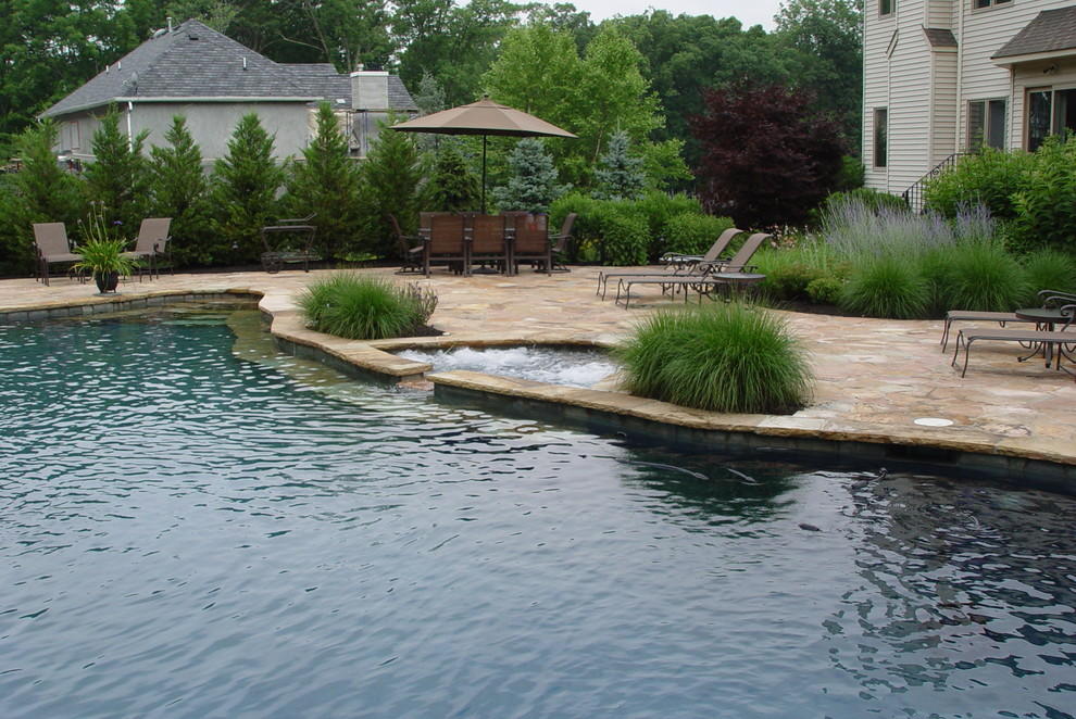 На фото: бассейн среднего размера, произвольной формы на заднем дворе в морском стиле с фонтаном и покрытием из каменной брусчатки с