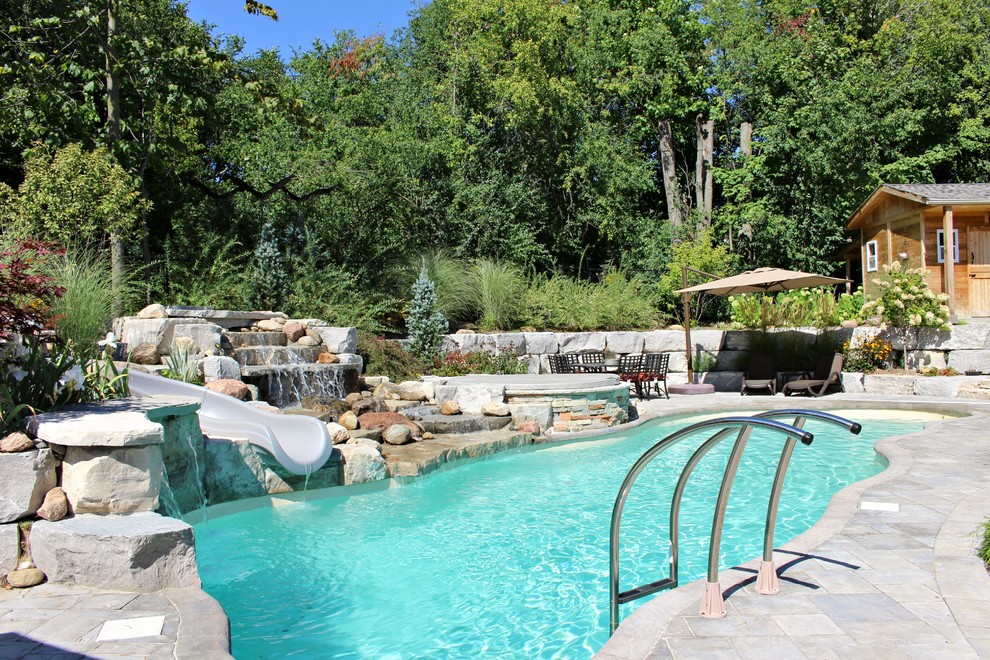 Modelo de casa de la piscina y piscina tradicional grande a medida en patio trasero con adoquines de ladrillo