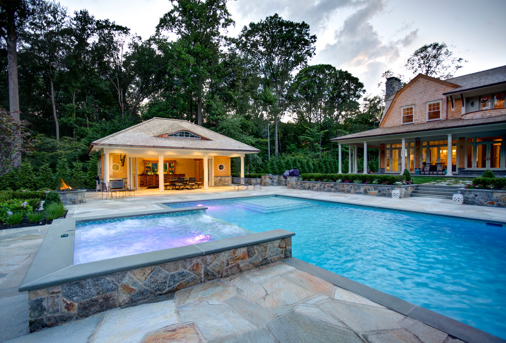Foto de piscinas y jacuzzis alargados de estilo de casa de campo de tamaño medio rectangulares en patio trasero con adoquines de piedra natural