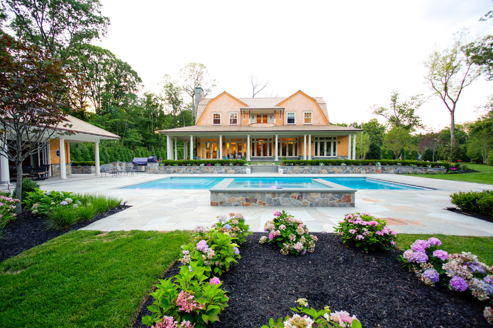 Ejemplo de piscinas y jacuzzis alargados campestres de tamaño medio rectangulares en patio trasero con adoquines de piedra natural