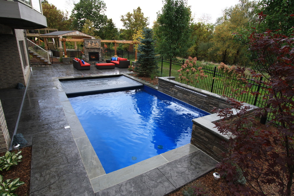 Свежая идея для дизайна: прямоугольный бассейн среднего размера на заднем дворе в современном стиле с фонтаном и покрытием из бетонных плит - отличное фото интерьера