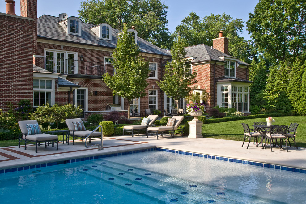Diseño de piscina alargada clásica extra grande rectangular en patio trasero con losas de hormigón