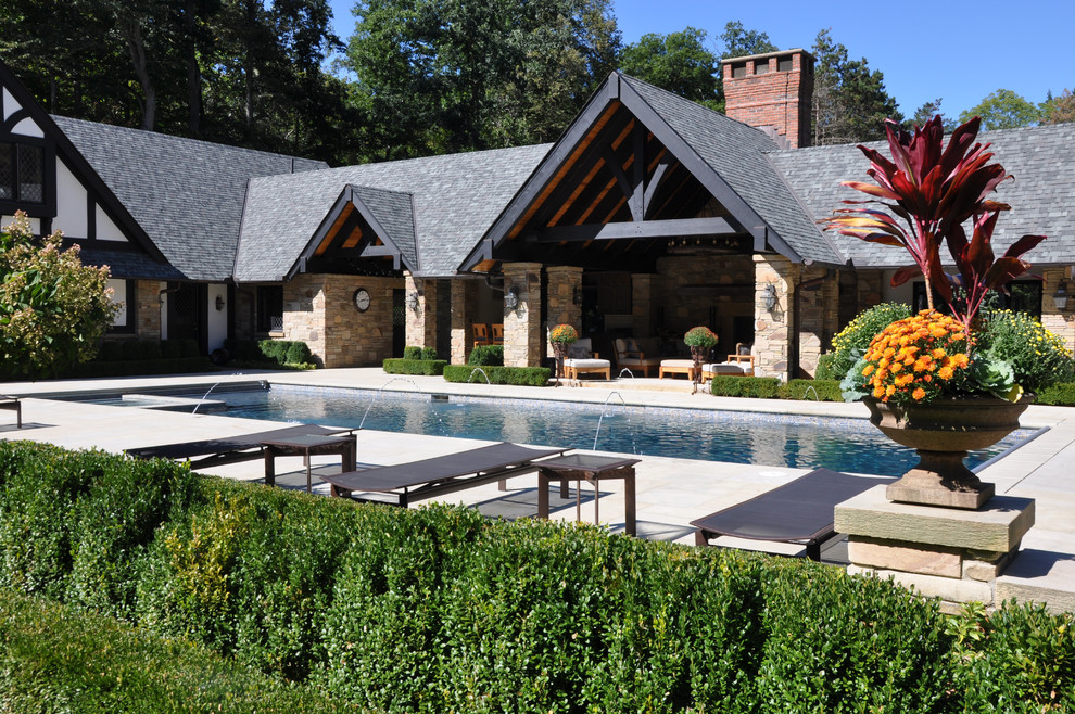 Pool fountain - large traditional backyard stone and rectangular pool fountain idea in Cleveland