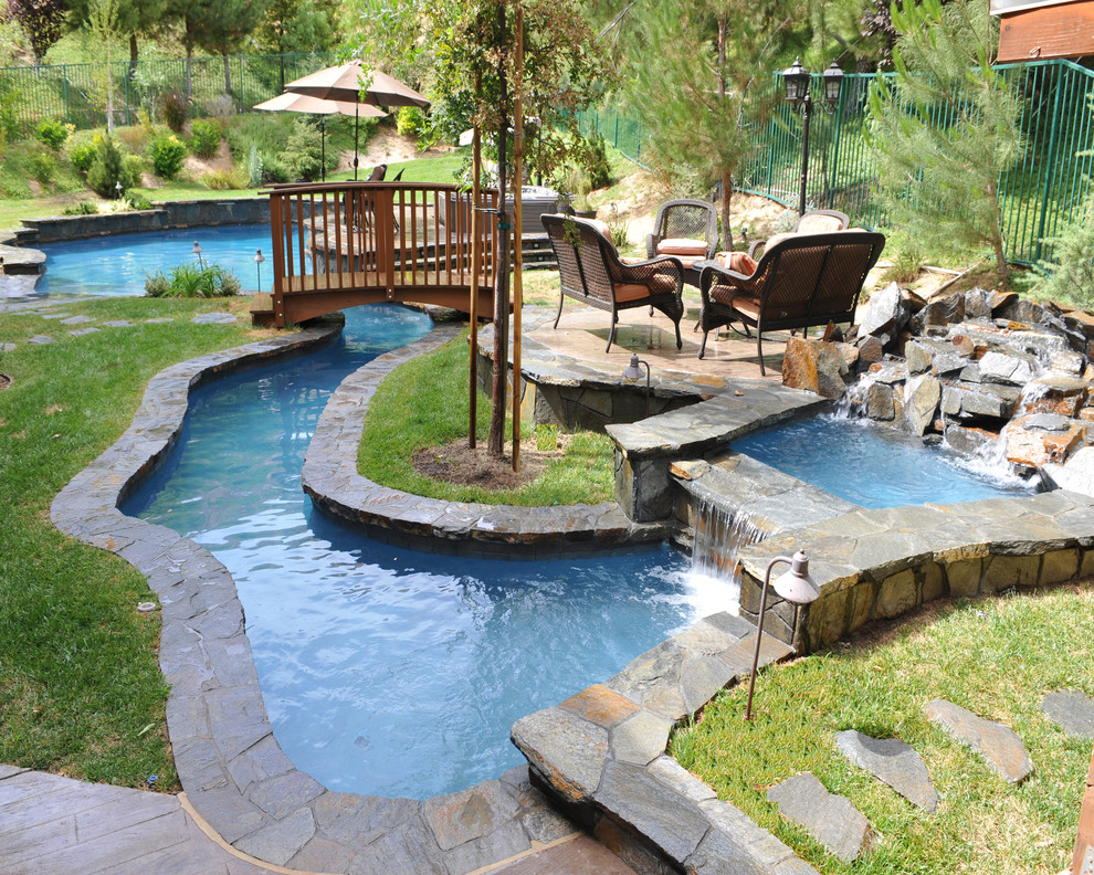 На фото: естественный бассейн произвольной формы в восточном стиле с покрытием из каменной брусчатки и забором