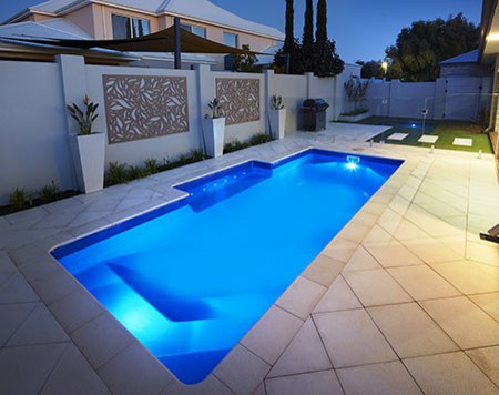 Imagen de piscina con fuente alargada contemporánea de tamaño medio rectangular en patio trasero con adoquines de piedra natural