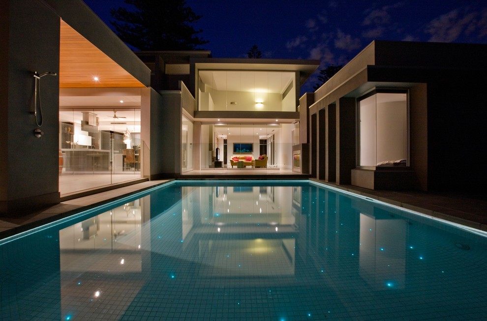 Foto de piscina con fuente grande rectangular en patio trasero con adoquines de piedra natural