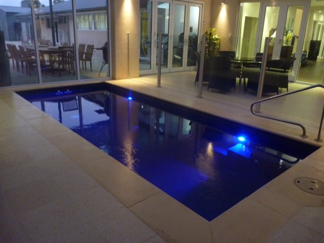 Cette photo montre une petite piscine intérieure moderne rectangle avec des pavés en pierre naturelle.