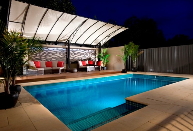 Esempio di una grande piscina minimalista rettangolare dietro casa con pavimentazioni in pietra naturale