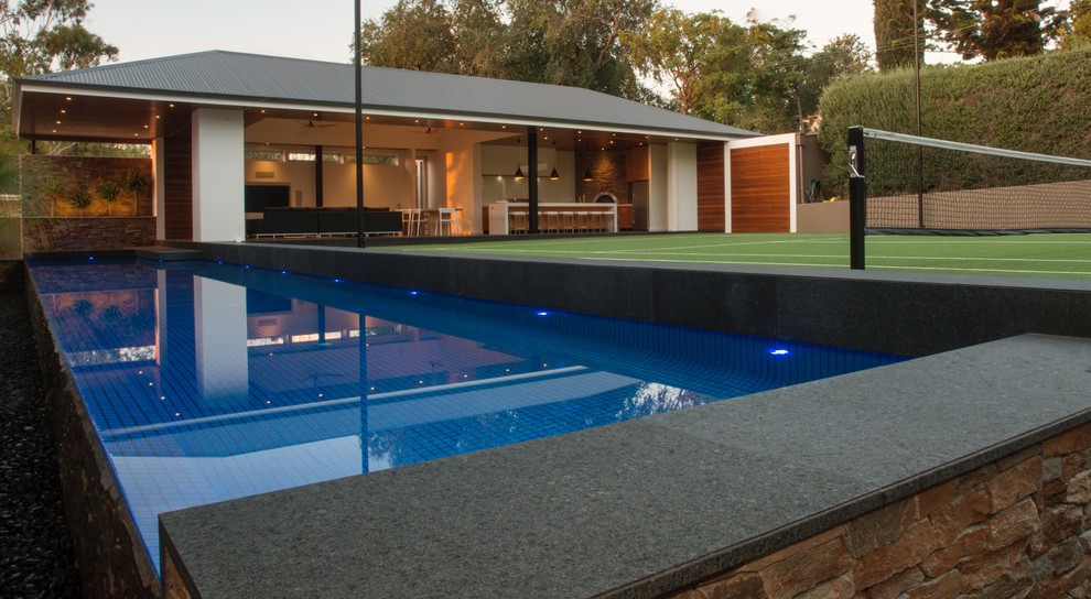Imagen de piscina infinita moderna grande a medida en patio trasero