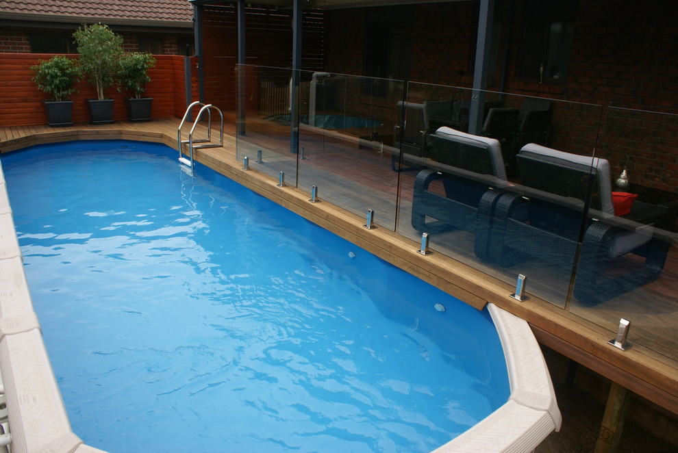 Aménagement d'une petite piscine hors-sol et arrière moderne ronde avec une terrasse en bois.