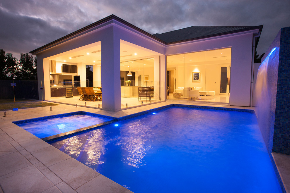 Mittelgroßer Moderner Pool hinter dem Haus in rechteckiger Form mit Wasserspiel und Natursteinplatten in Adelaide