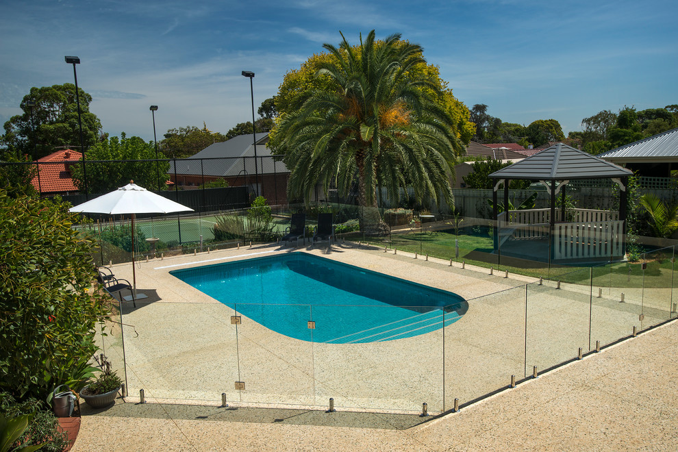 Esempio di una piscina moderna personalizzata di medie dimensioni e dietro casa con piastrelle