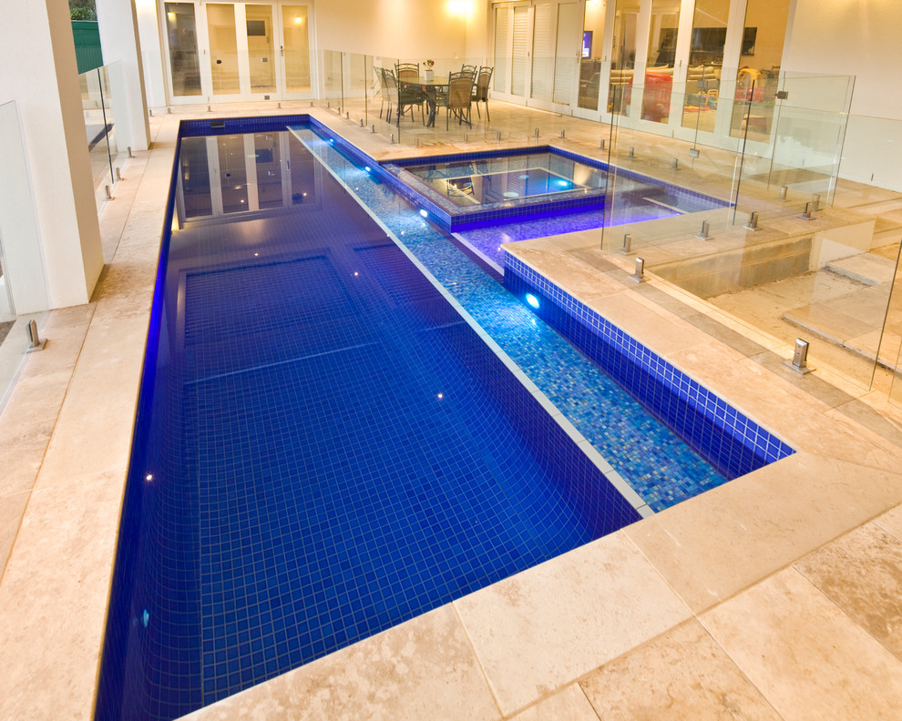 Imagen de piscina alargada moderna de tamaño medio rectangular en patio trasero con suelo de baldosas