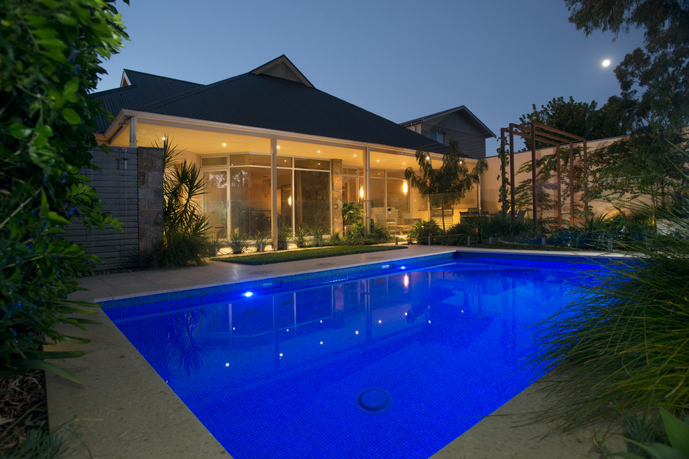 Immagine di una piscina moderna rettangolare di medie dimensioni e dietro casa con pavimentazioni in cemento
