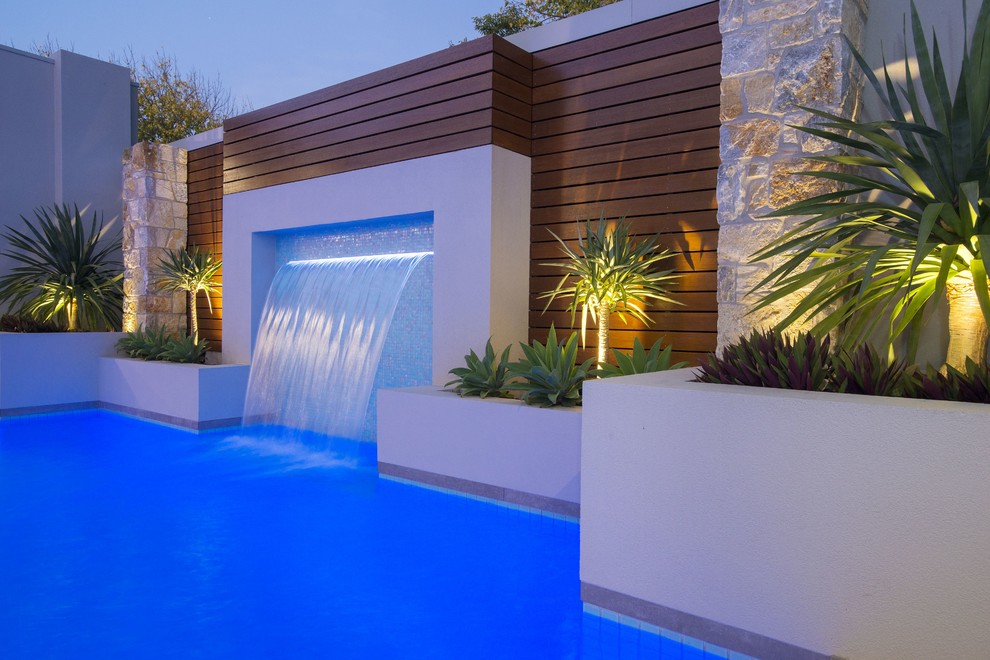 Ispirazione per una piscina moderna rettangolare di medie dimensioni e dietro casa con fontane