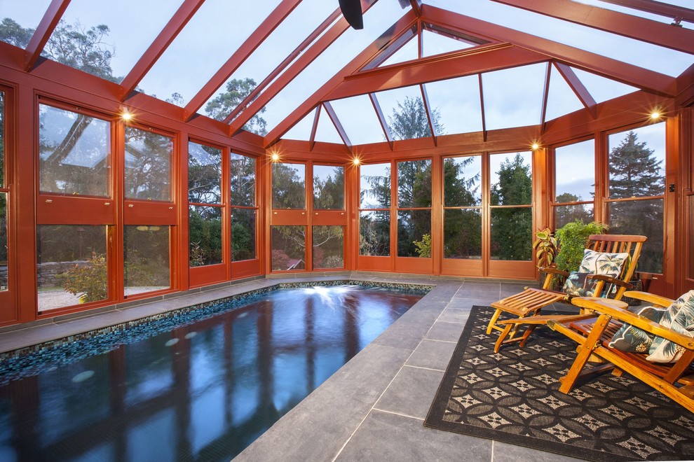 Cette image montre une piscine intérieure design rectangle avec des pavés en pierre naturelle.