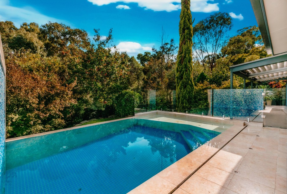 Idée de décoration pour une piscine à débordement et arrière design de taille moyenne et rectangle avec un point d'eau et des pavés en pierre naturelle.