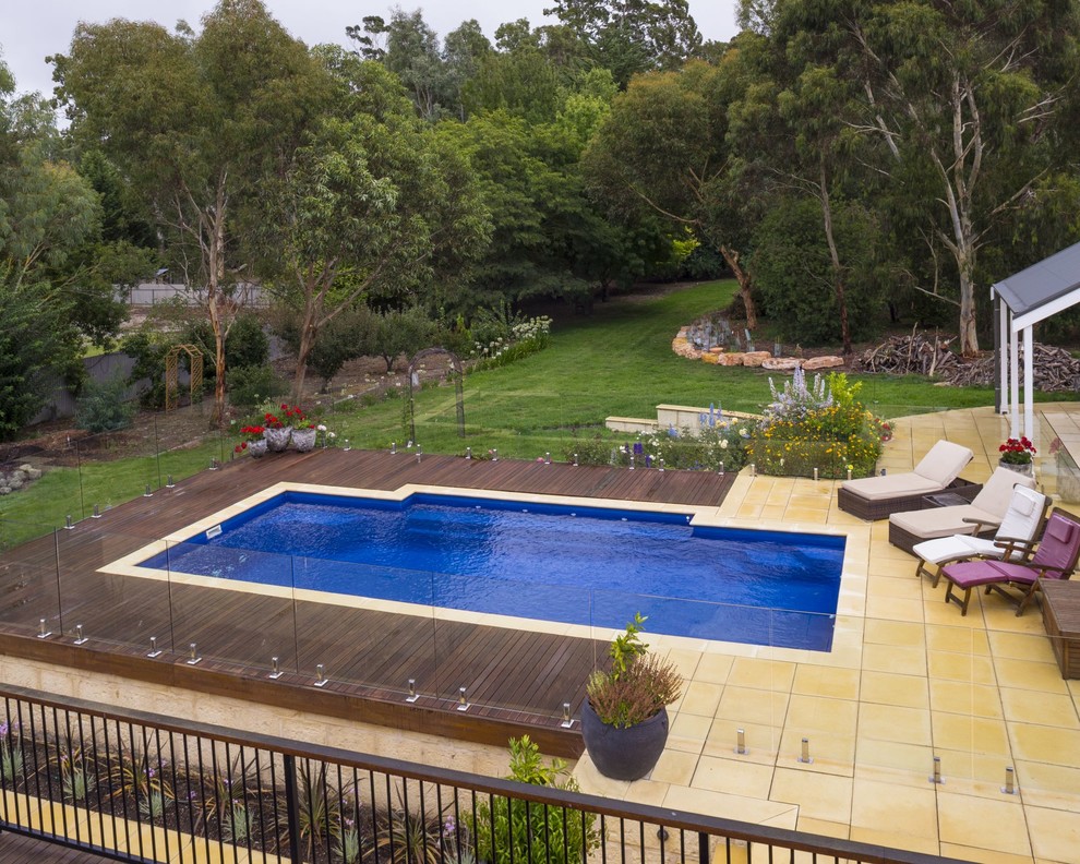 Imagen de piscina moderna de tamaño medio rectangular en patio trasero con entablado
