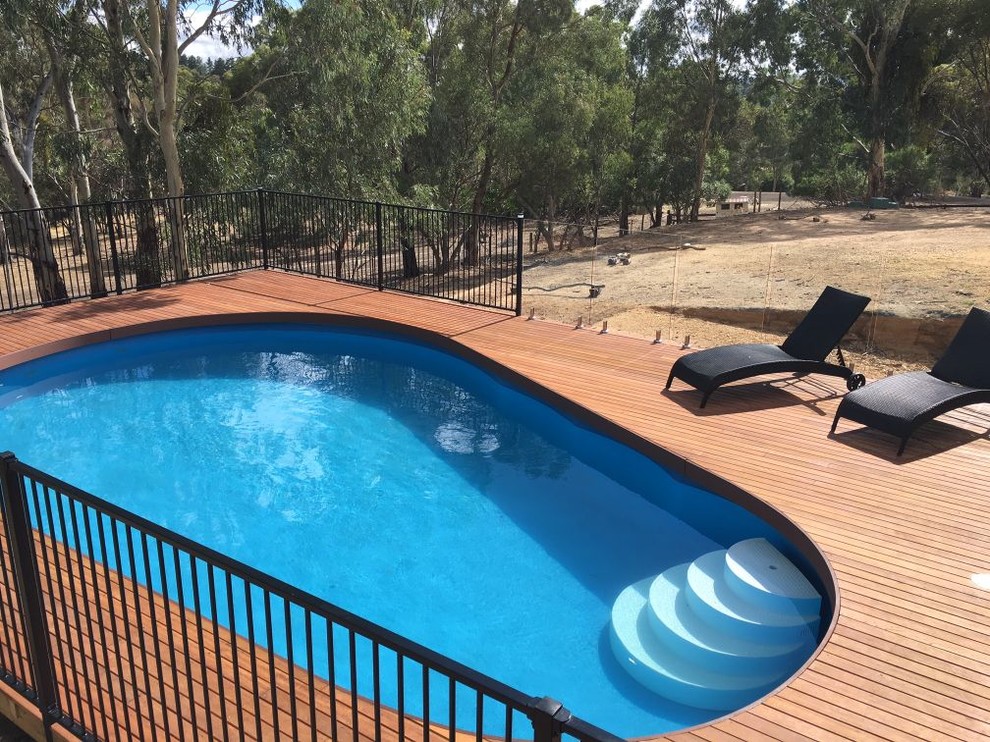 Esempio di una piscina minimal rotonda di medie dimensioni e dietro casa con pedane