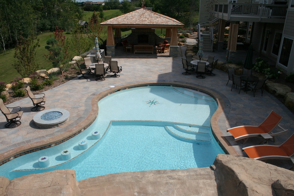 Ispirazione per una grande piscina naturale tradizionale a "C" dietro casa con una dépendance a bordo piscina e pavimentazioni in cemento