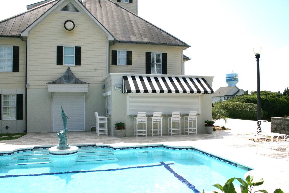 Immagine di una grande piscina monocorsia stile marinaro rettangolare dietro casa con una dépendance a bordo piscina e piastrelle