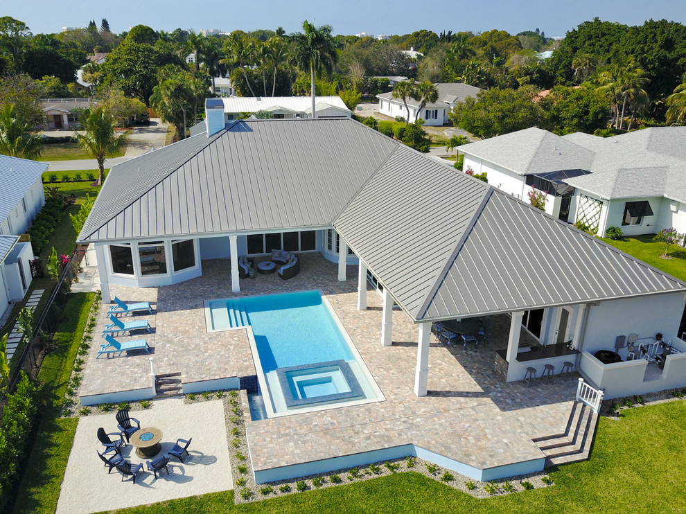 Großer Klassischer Pool hinter dem Haus in rechteckiger Form mit Natursteinplatten in Miami