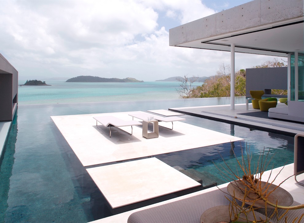 Inspiration for a large modern back custom shaped infinity swimming pool in Townsville with a pool house.