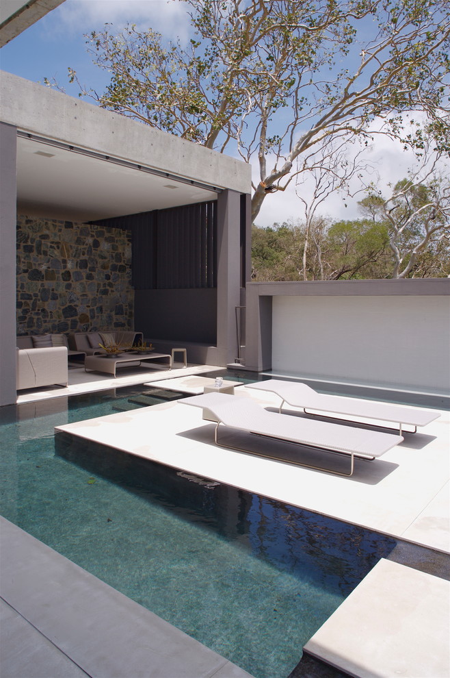 Medium sized modern custom shaped swimming pool in Townsville with a pool house.