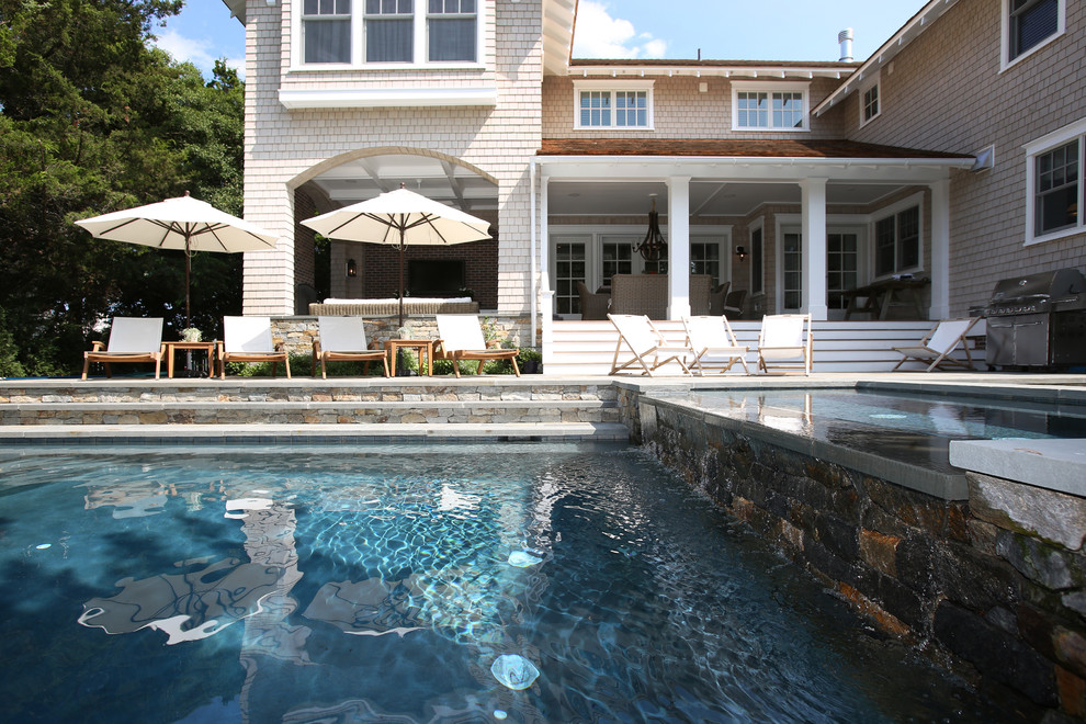 Esempio di una piscina naturale stile americano rettangolare di medie dimensioni e dietro casa con pavimentazioni in mattoni
