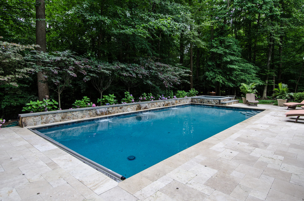 Ispirazione per una grande piscina monocorsia american style rettangolare dietro casa con fontane e pavimentazioni in pietra naturale