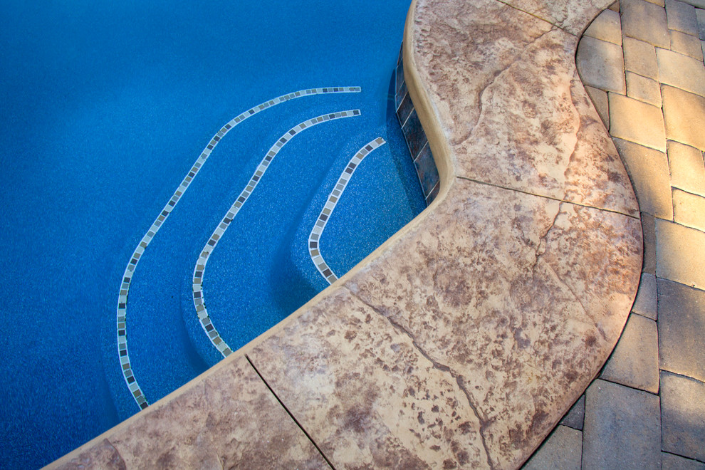 Modelo de piscinas y jacuzzis naturales tradicionales renovados extra grandes a medida en patio trasero con adoquines de piedra natural
