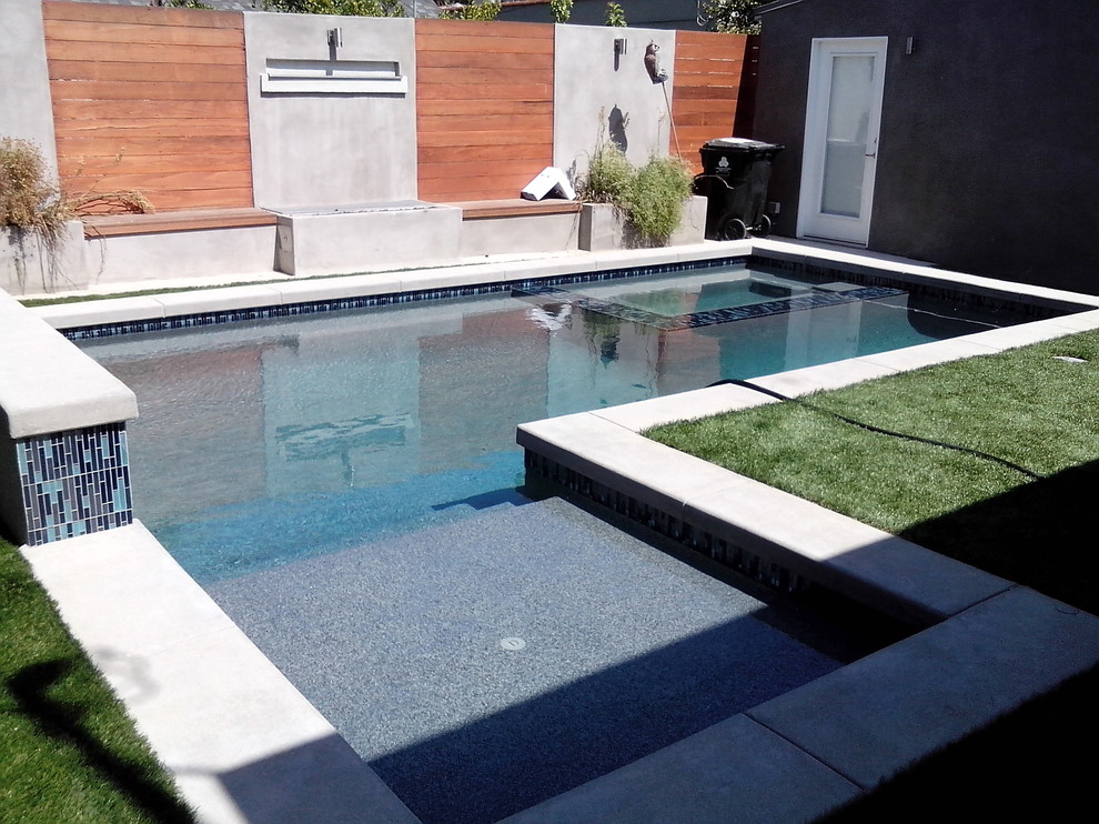 Свежая идея для дизайна: угловой бассейн среднего размера на заднем дворе в стиле модернизм с джакузи и мощением тротуарной плиткой - отличное фото интерьера