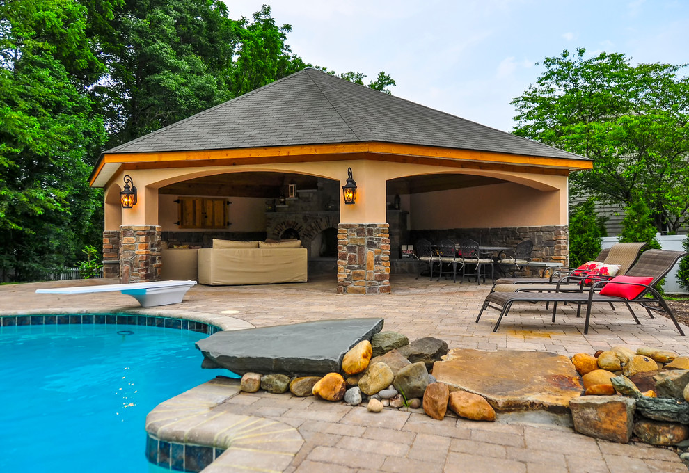 Diseño de casa de la piscina y piscina alargada rural rectangular en patio trasero con adoquines de piedra natural