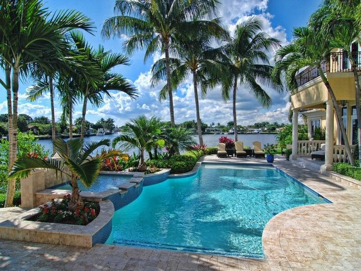 Inspiration for a mid-sized tropical backyard stone and custom-shaped pool remodel in Miami