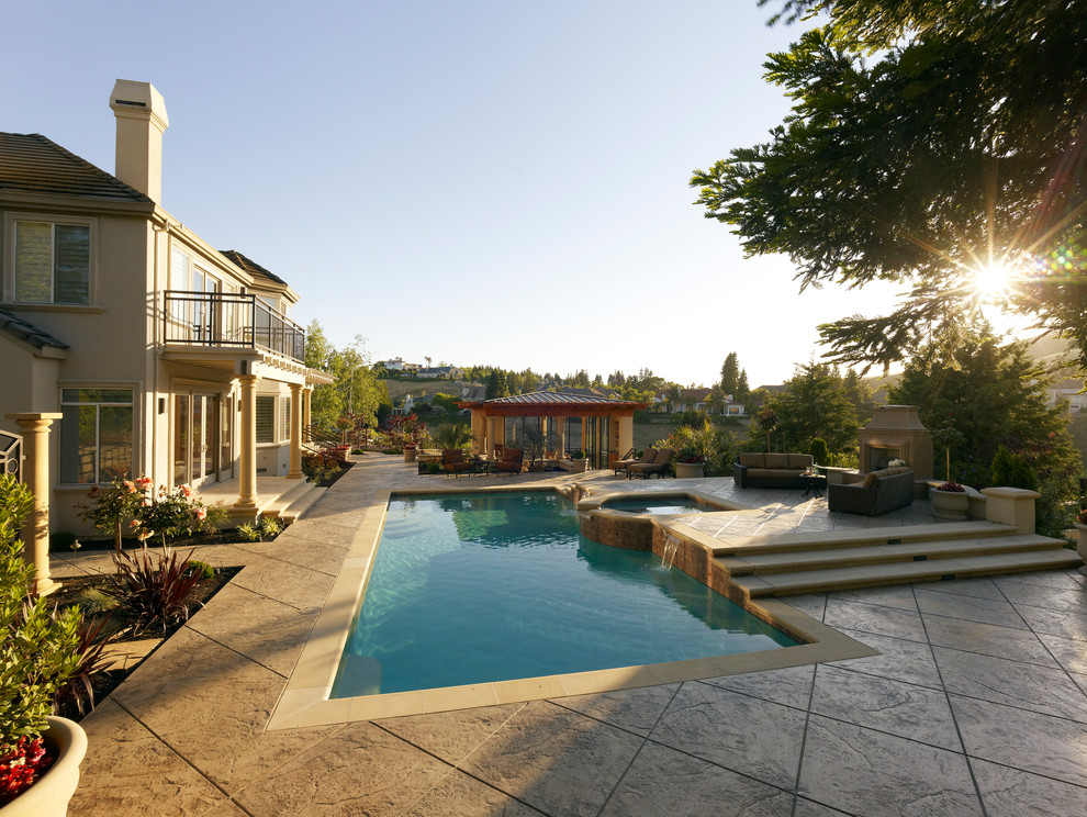 Diseño de casa de la piscina y piscina alargada clásica extra grande rectangular en patio trasero con adoquines de hormigón