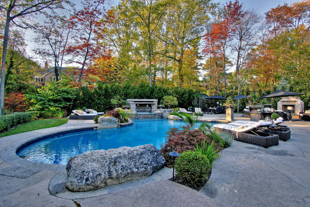 Стильный дизайн: большой естественный бассейн произвольной формы на заднем дворе в стиле неоклассика (современная классика) с джакузи и покрытием из каменной брусчатки - последний тренд