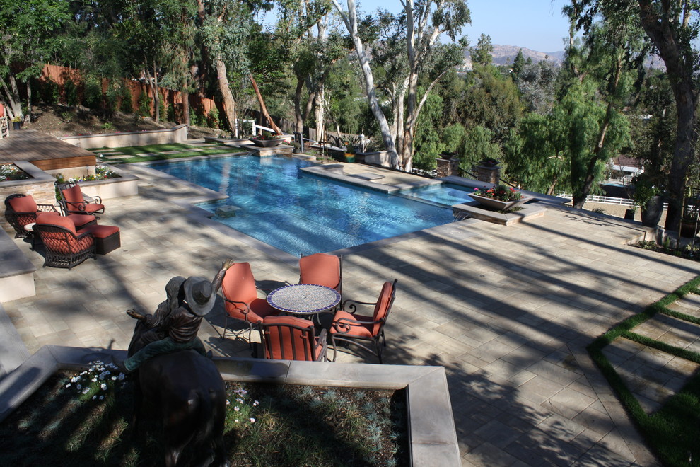 Large trendy backyard concrete paver and custom-shaped infinity pool fountain photo in Los Angeles