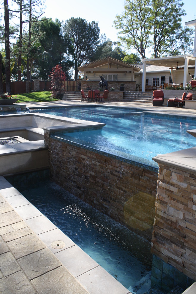 Стильный дизайн: бассейн-инфинити среднего размера, произвольной формы на заднем дворе в средиземноморском стиле с фонтаном и покрытием из каменной брусчатки - последний тренд