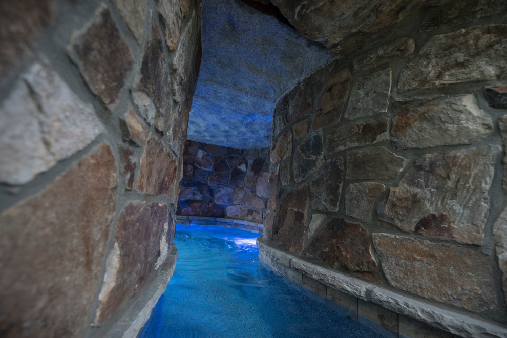 Aménagement d'un très grand piscine avec aménagement paysager arrière exotique sur mesure avec des pavés en brique.
