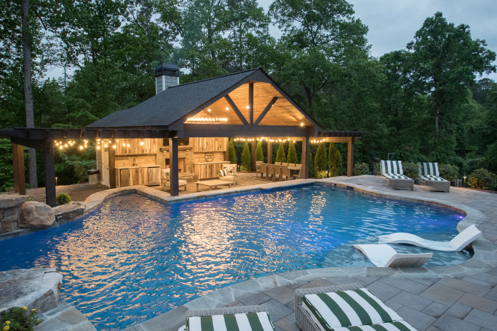 Diseño de piscina natural exótica extra grande a medida en patio trasero con paisajismo de piscina y adoquines de ladrillo