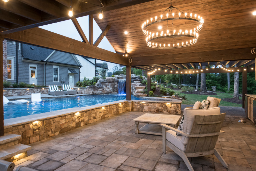 Diseño de piscina natural exótica extra grande a medida en patio trasero con paisajismo de piscina y adoquines de ladrillo