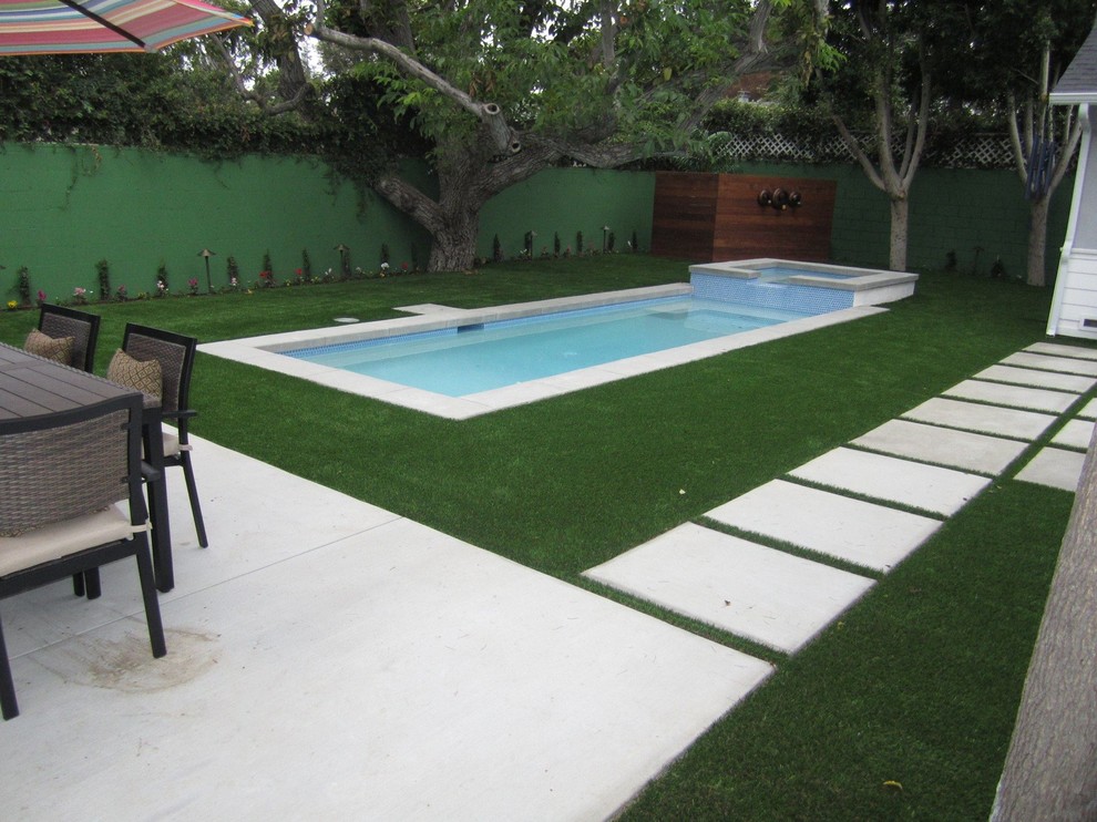 Esempio di una piccola piscina monocorsia moderna rettangolare dietro casa con una vasca idromassaggio e pavimentazioni in cemento
