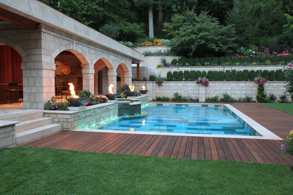 Ejemplo de piscina mediterránea rectangular en patio trasero con entablado
