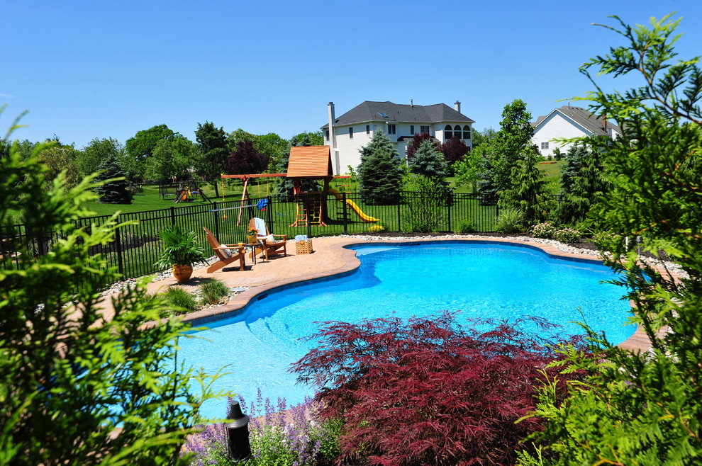 Foto de piscina con fuente rural de tamaño medio a medida en patio trasero con adoquines de hormigón
