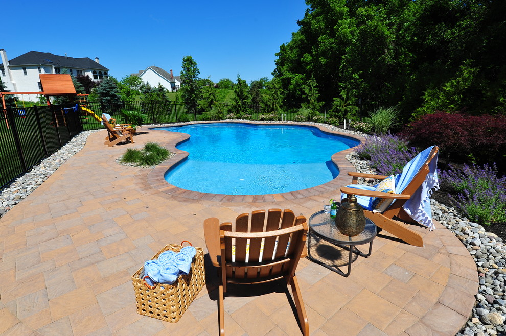 Imagen de piscina con fuente tradicional de tamaño medio a medida en patio trasero con adoquines de hormigón