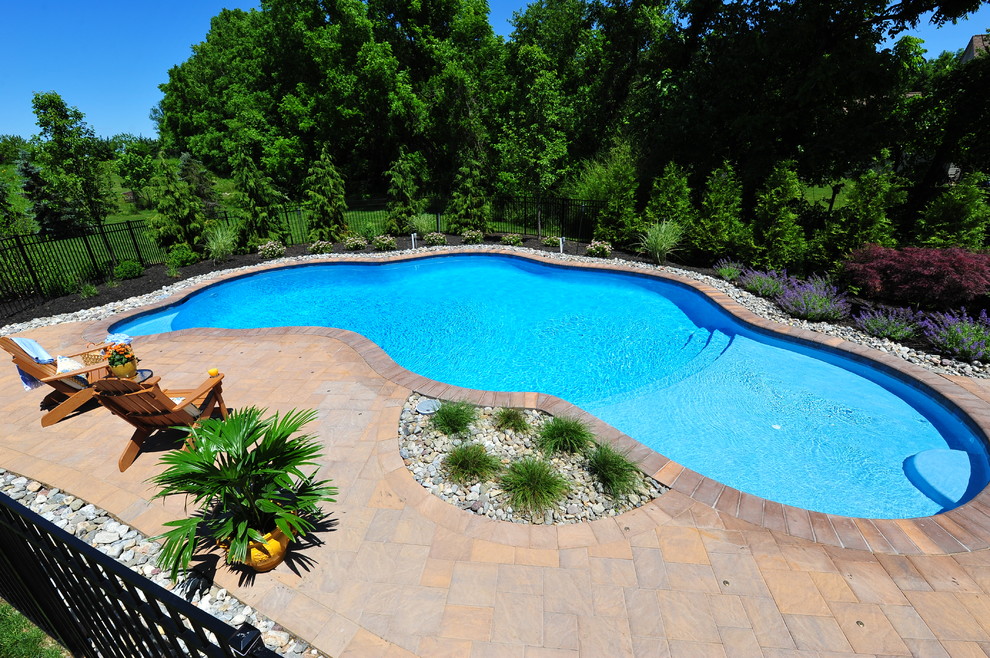 Immagine di una piscina chic personalizzata di medie dimensioni e dietro casa con fontane e pavimentazioni in cemento